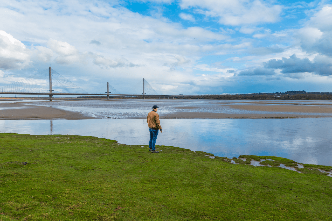 Man looking across the Mersey river.